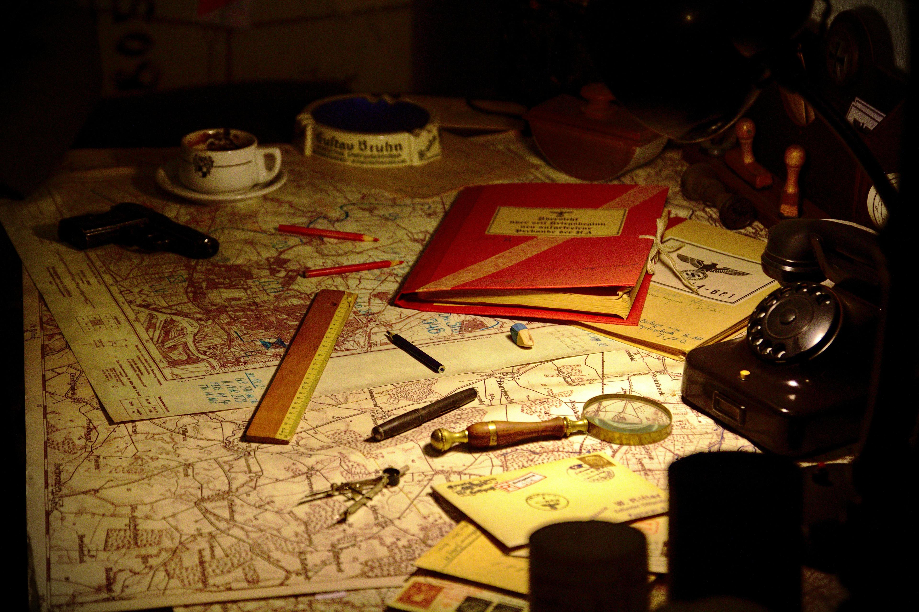 A map, pencils, and notebook laid out for a murder mystery investigation